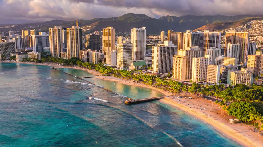 Aerial view of Waikiki Beach with high-rise hotels along the shoreline and turquoise ocean waters in Honolulu, Hawaii, United States.