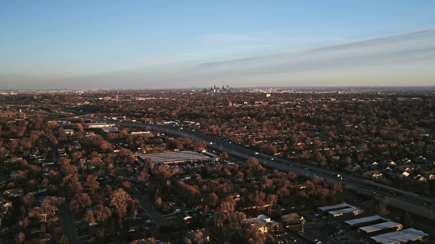 Aerial view of Denver skyline at sunset with highway and residential areas in Denver, Colorado, United States.