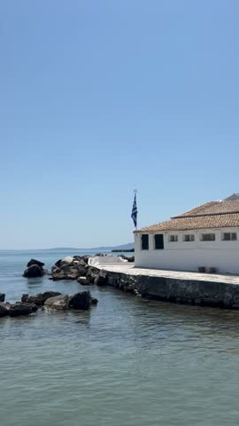Holy Monastery of Panagia Vlacherna, white church on a small peninsula in turquoise sea, Kanoni, Corfu, Greece