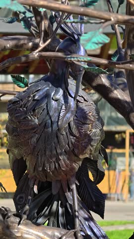 A statue of a bird perched on a tree branch.