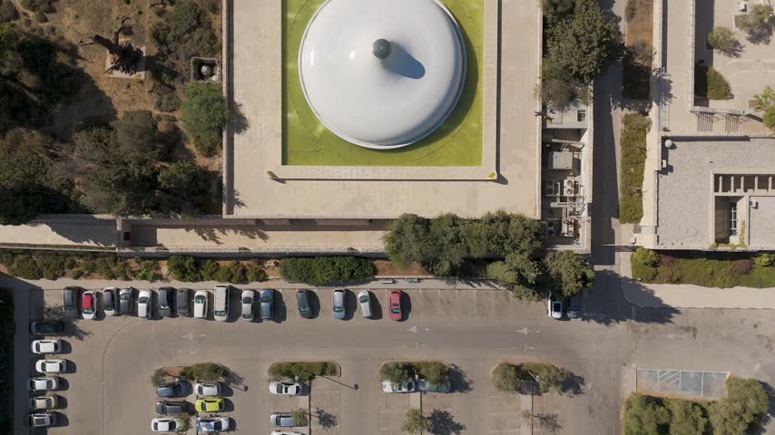 Aerial view of the Shrine of the Book at The Israel Museum surrounded by lush trees and a parking lot in Jerusalem, Jerusalem District, Israel.