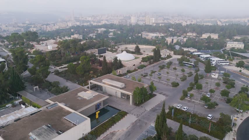 Aerial view of The Israel Museum with its iconic white dome surrounded by trees and parking areas in Jerusalem, Jerusalem District, Israel.