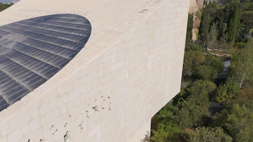 Aerial view of National Library of Israel with its distinctive stone facade and solar panels on the roof, surrounded by lush greenery in Jerusalem, Jerusalem District, Israel.