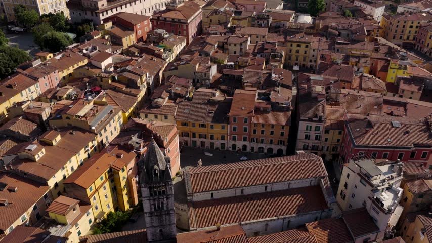 Aerial view of the historic city center of Carrara, featuring the Duomo di Carrara surrounded by dense terracotta-roofed buildings and narrow streets in Carrara, Tuscany, Italy.
