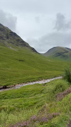 View from car window of the River Etive next to mountains while driving on the Glen Etive single-track road in the summer in Glencoe in the Scottish Highlands, Scotland, United Kingdom