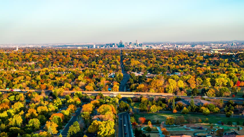 Aerial view of Denver skyline surrounded by vibrant autumn foliage and urban streets in Denver, Colorado, United States.