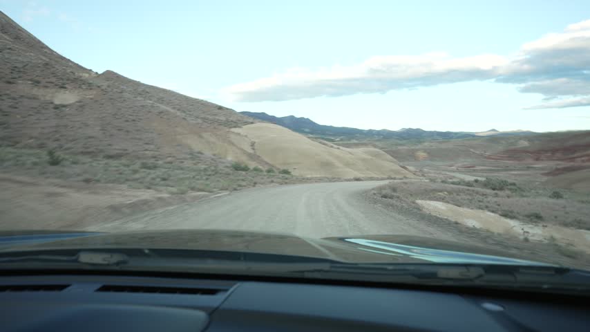 Driving POV on a gravel road through the Painted Hills in Oregon