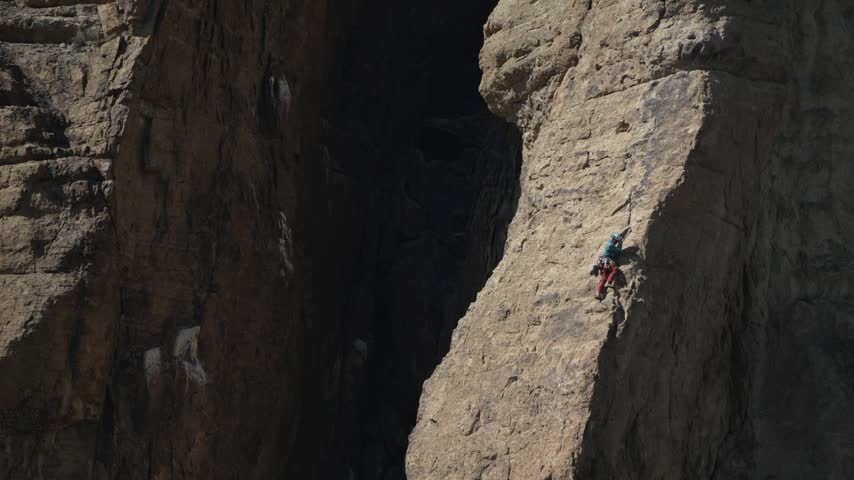 Rock climber scaling a sunlit cliff at Smith Rock State Park Oregon