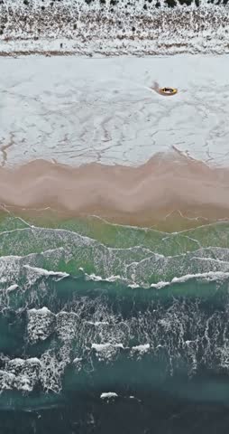 Aerial view of boats on beach by Baltic sea in winter in Poland.
