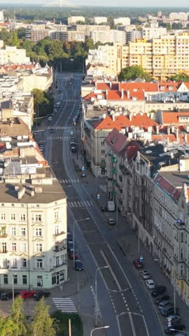 Aerial view of Wroclaw, Poland, showcasing urban architecture with red rooftops, tree-lined streets, and a vibrant cityscape under clear blue skies