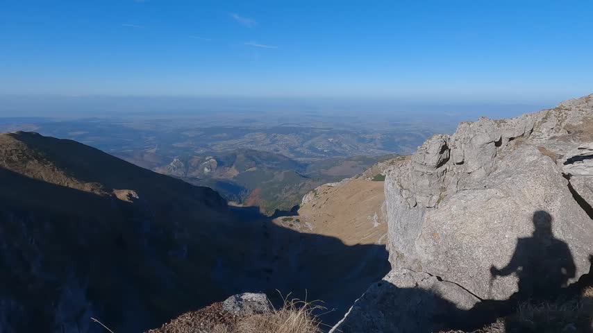 Large rock ledge frames a distant foothill panorama from the high Czerwone Wierchy route