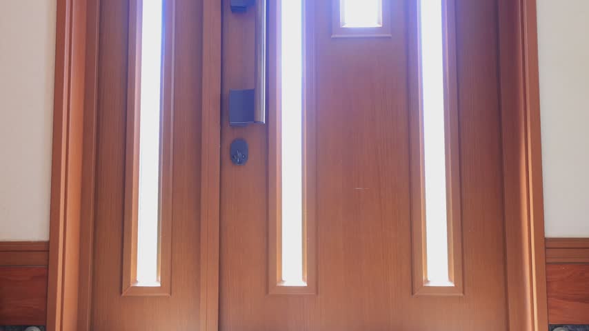 Silhouette of a Visitor Standing Outside the Front Door Through Frosted Glass