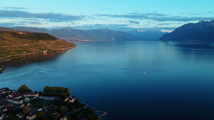 Drone pulls back from Lake Geneva toward the town of Cully, Switzerland