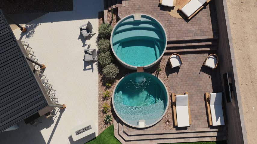 Top-down aerial view of two circular pools connected by a flowing waterfall