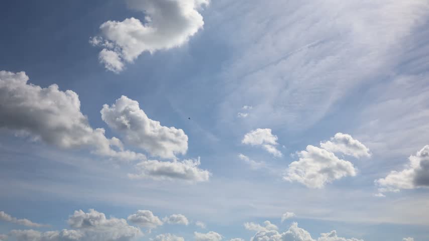 Military fighter jet flies beneath dramatic clouds across a vast blue sky during aerial demonstration showing speed agility altitude and modern combat aviation technology