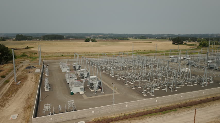 Large substation next to farmland in Oregon, slow drone tracking shot.