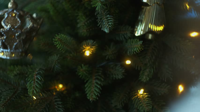 Woman decorating Christmas tree with Christmas ornaments.