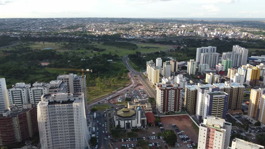 Brasilia, Brazil, showing a church surrounded by modern residential towers, roads, green space and extensive urban development stretching toward the horizon, aerial view