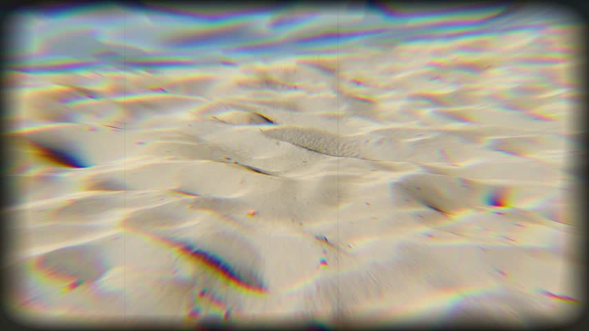 Close up shot of textured sand dunes with a chromatic aberration glitch effect creating a surreal look.