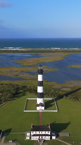 Bodie Island Lighthouse In The Outer Banks Of North Carolina, Surrounded By Coastal Marshlands And The Distant Atlantic Ocean. vertical, aerial shot