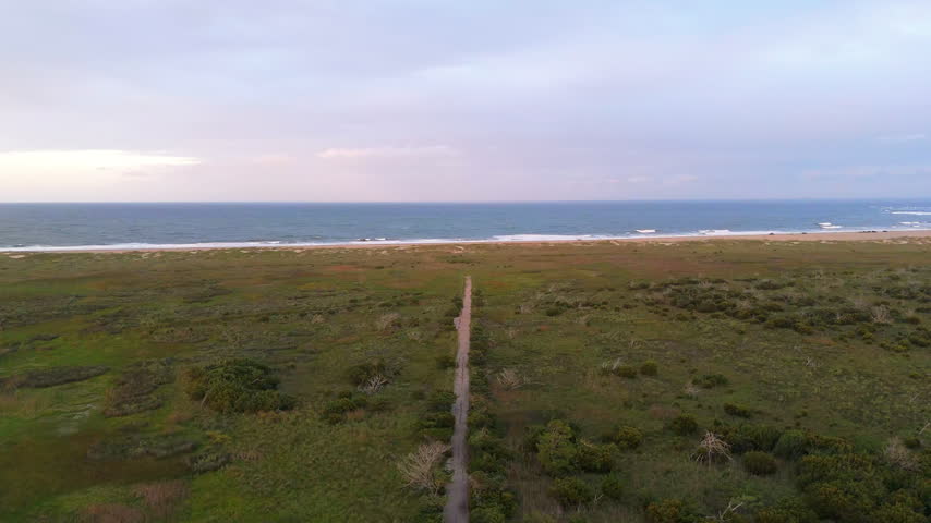 Aerial View Of Coastal Landscape With Narrow Path Towards Sandy Beach And Ocean Waves On Hatteras Island, North Carolina.