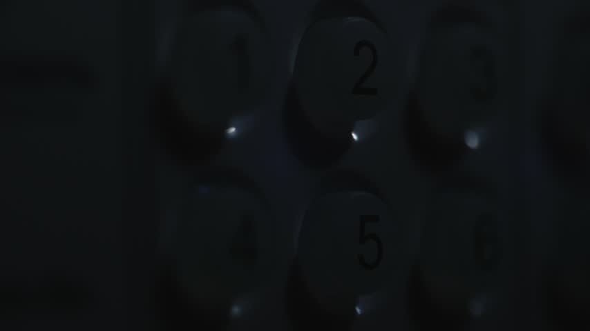 Macro shot of hand entering security code on digital lock interface. Professional cinematic footage of biometric access control system featuring illuminated numerical keypad in low light.