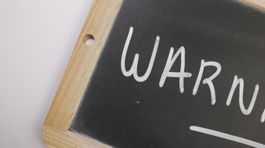 Warning written in English on a black slate