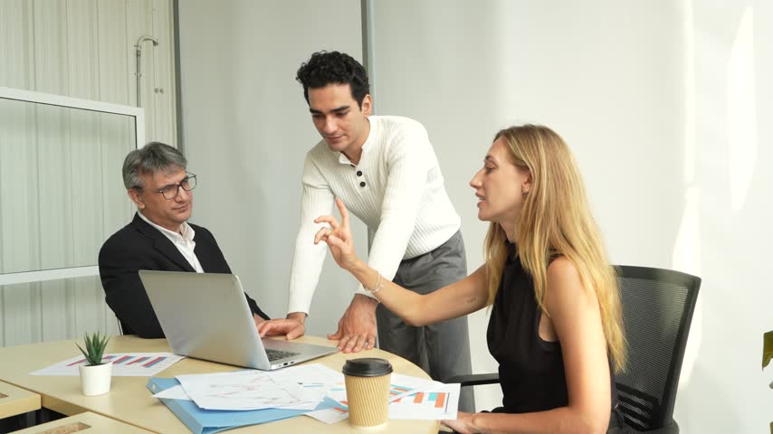 A group of male business professionals is presenting to a male executive and a female secretary during a meeting in a corporate conference room.
