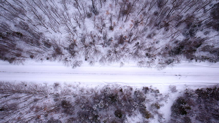 Aerial shot of a snow-covered road through the Northern Michigan landscape