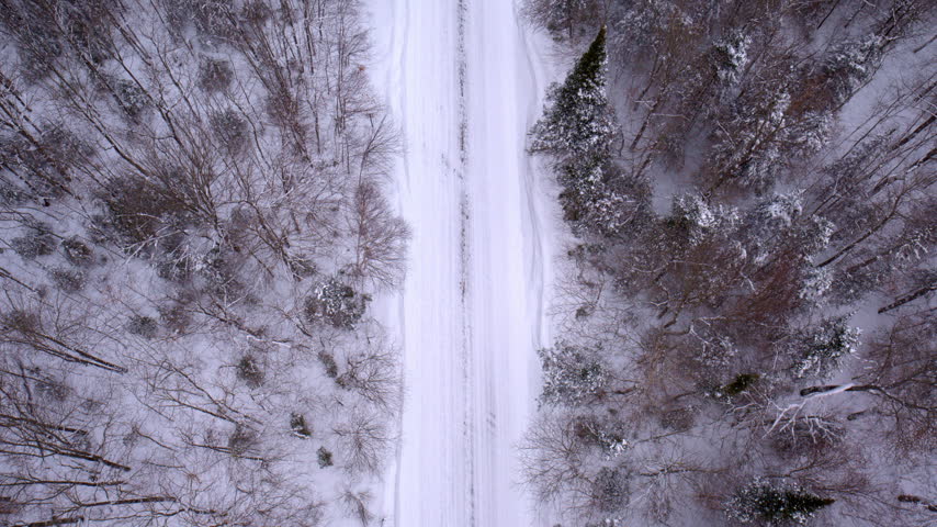 Aerial view of a snow-covered landscape and winding road in Northern Michigan