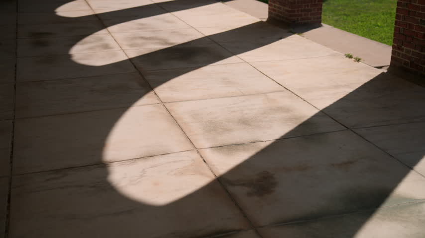 Artistic shot of sunlight and column shadows falling across the stone patio at the Hall of Springs in Saratoga Springs, New York, creating dramatic geometric patterns.