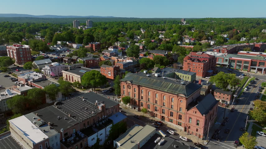Aerial view of the historic Saratoga Springs City Hall in downtown Saratoga Springs, New York, framed by tree-lined streets and lush green residential neighborhoods.