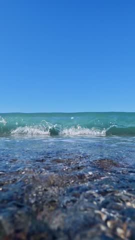 Waves crashing onto pebble beach.