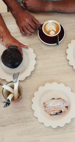 Above, hands and friends at cafe with dessert, pastries and relax together with morning food. Customers, drink or people with breakfast at coffee shop, chocolate muffin or eating treats with top view