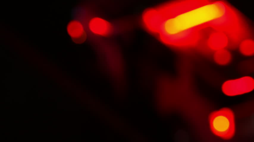 Police car with flashing red and blue emergency lights parked at night accident scene. Service vehicle in bokeh blur. Police law enforcement vehicle lights flashing glow red and blue in crime scene.