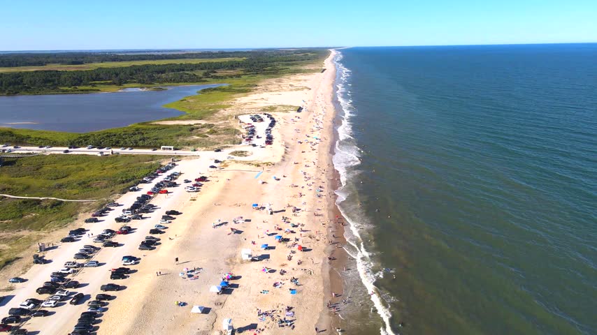 Beach parking and an access road border coastal wetlands near Chincoteague in Virginia.
