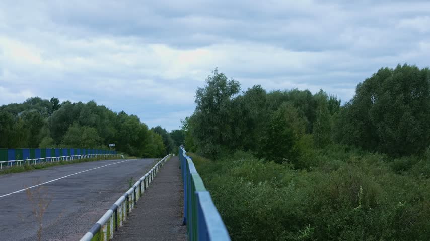Elevated roadway with metal guardrails over forested valley, Byten Belarus