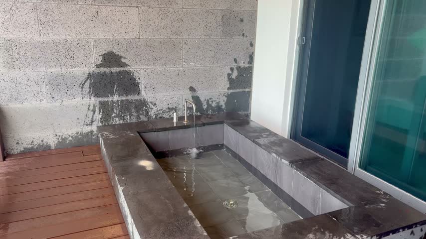 Clear water filling up an outdoor open-air hot spring bath