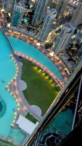 Top-down aerial view of the illuminated Burj Lake and downtown Dubai skyline at night
