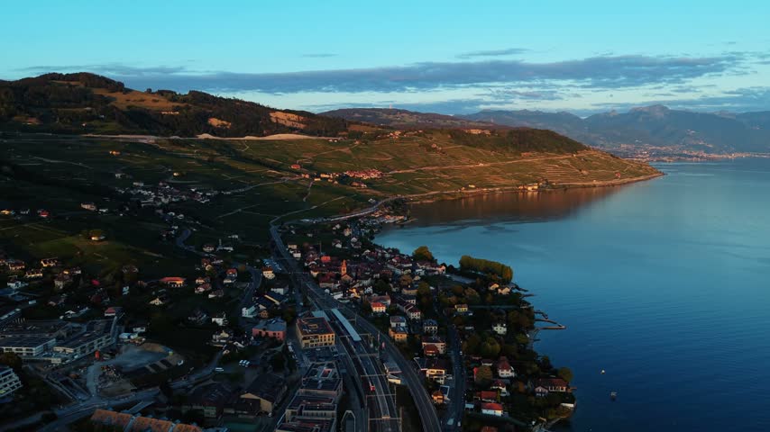 Drone flies along the coastal road by Lake Geneva near Cully, Switzerland