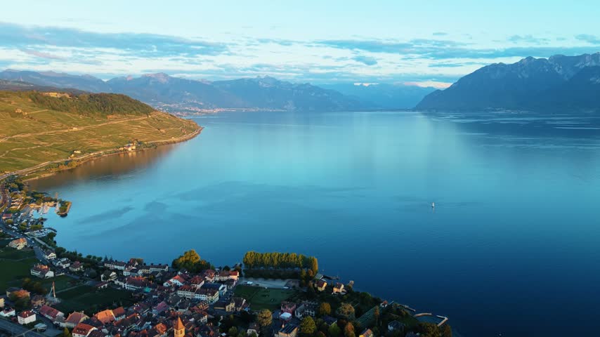 Drone flies forward toward Lake Geneva near Cully, Switzerland, mountains beyond