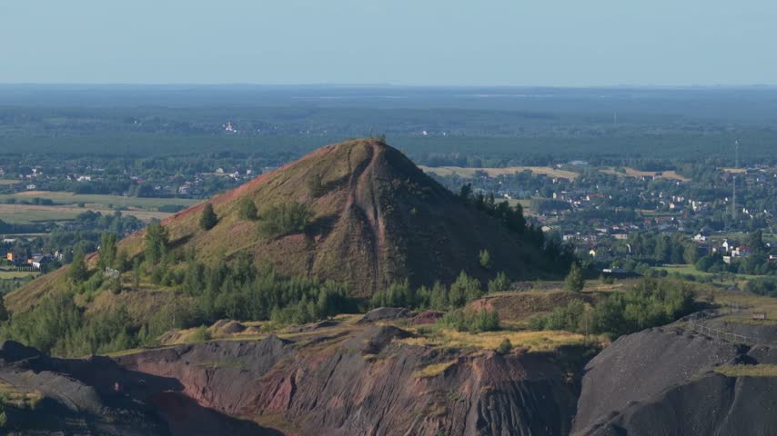 Panoramic view of a post-mining landscape with reclaimed spoil heaps and a town in background