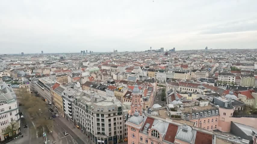Aerial view over Vienna, Austria, showing historic rooftops, city streets, dense architecture and the urban skyline.