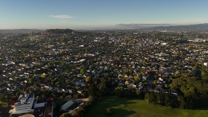 Aerial view of residential suburbs with houses and green parkland in Auckland New Zealand.