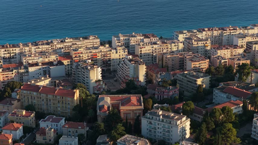 Static telephoto view of a Belle Epoque villa among pines, seafront apartment blocks and the calm blue sea behind, Nice, French Riviera, Cote d Azur, France