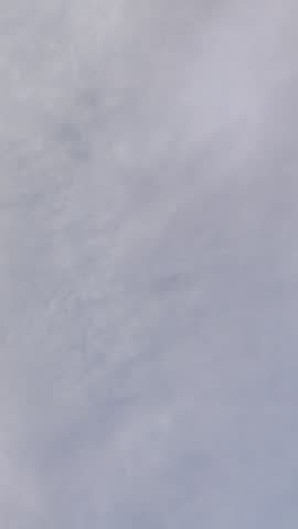 Airplane flying high across the cloudy sky