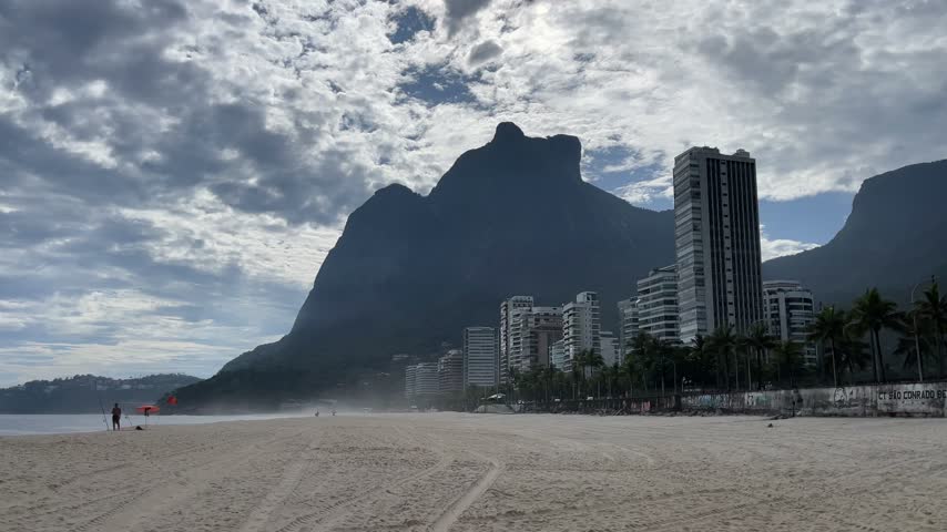 View of sandy beach and tall buildings with mountains in Rio De Janeiro Brazil