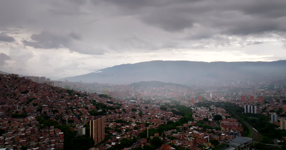 Dense residential neighborhoods with buildings covering hillsides in Medellin, Colombia. Aerial drone view, cityscape