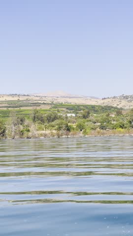 Scenic view of the Sea of Galilee water and green hills under a clear blue sky