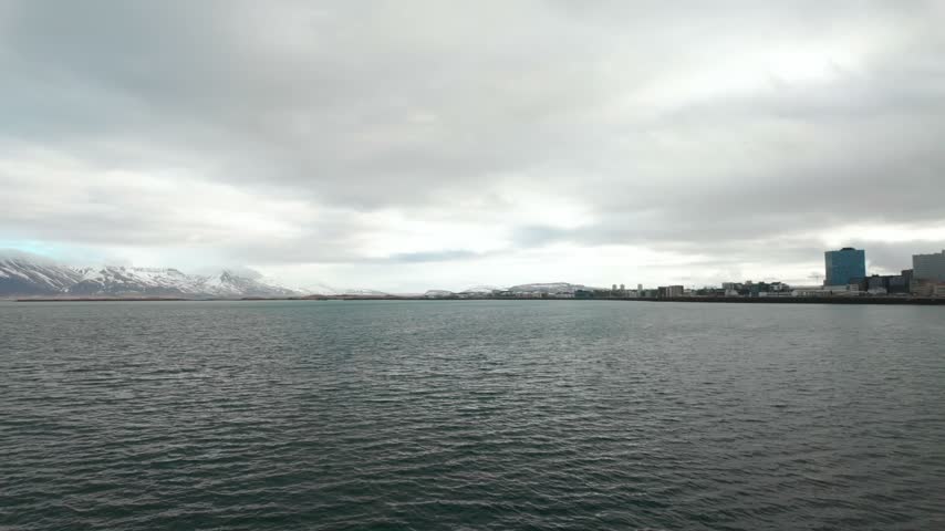 A view of the coast of Reykjavik, Iceland and the surrounding waters and mountains.